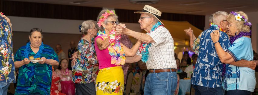 Senior adults couples dancing dressed in luau themed attire