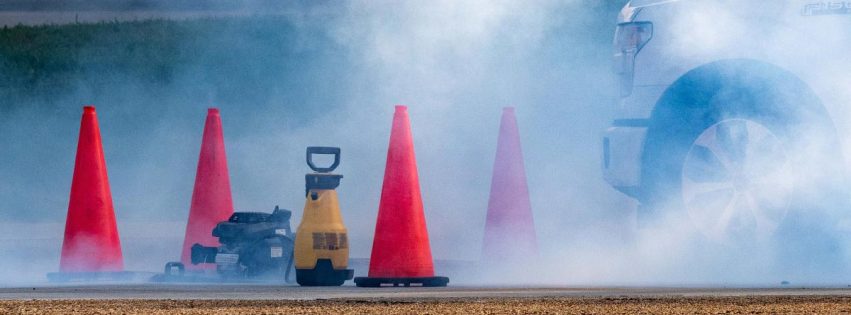 traffic cones around a cloud of smoke at a testing location