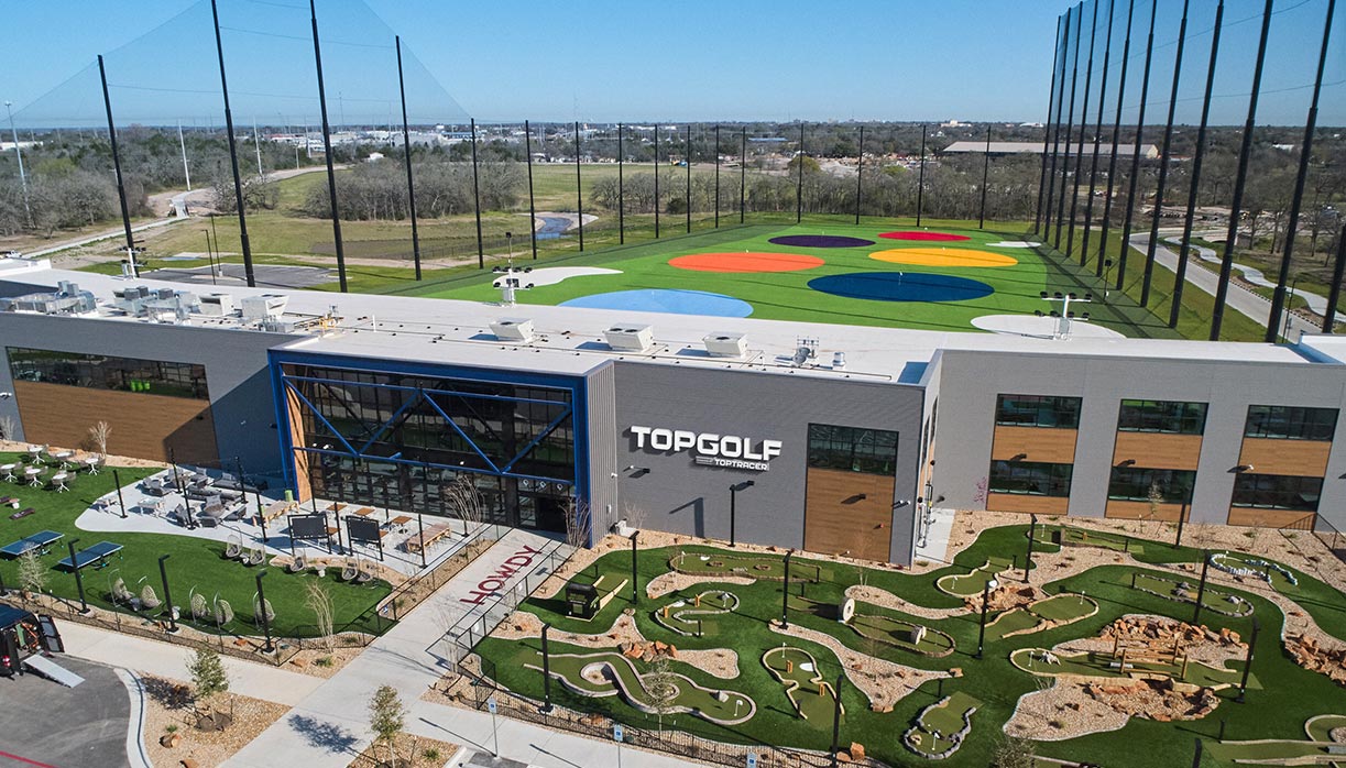 Aerial view of the TopGolf facility with minigolf course and colorful hitting range