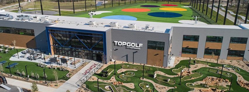 Aerial view of the TopGolf facility with minigolf course and colorful hitting range