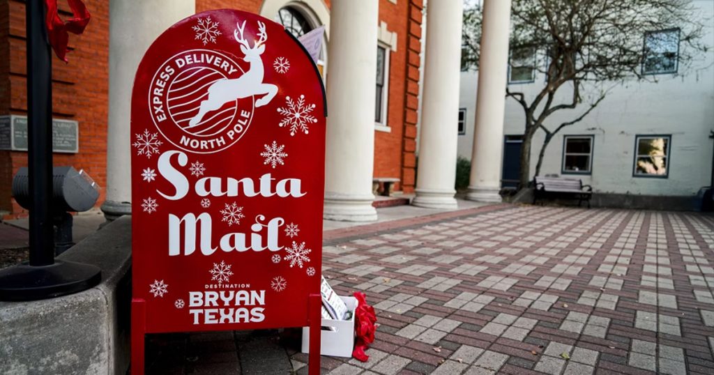 Red mailbox decorated with holiday motifs with text "Santa Mail"