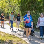 group of people walking down a park path