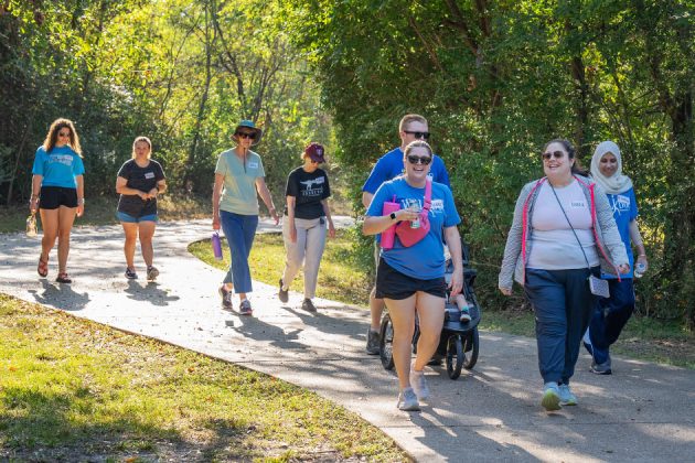 group of people walking down a park path