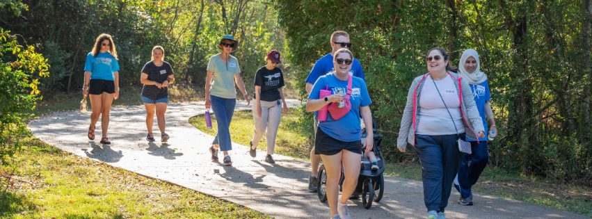 group of people walking down a park path