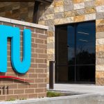 closeup of BTU brick sign with logo and the new facility building in the background