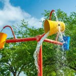 pole with three rotating buckets splashing water