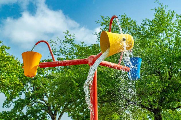 pole with three rotating buckets splashing water