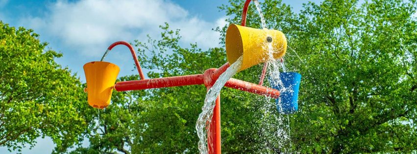 pole with three rotating buckets splashing water