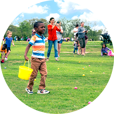 group of children collecting easter eggs in a field