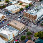 aerial image of downtown Bryan during an event with many pedestrians and parked vehicles