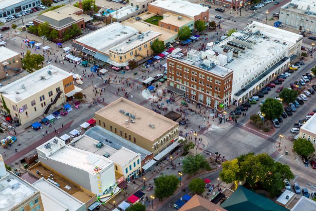 aerial image of downtown Bryan during an event with many pedestrians and parked vehicles